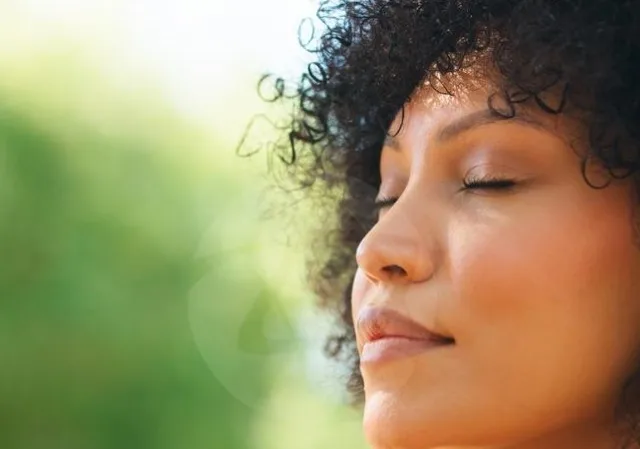 Mulher respirando de olhos fechados