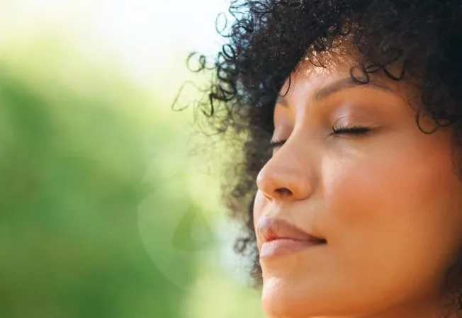 Mulher respirando de olhos fechados