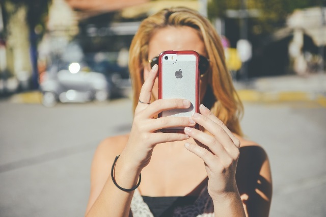 Moça segurando Iphone - Pixabay