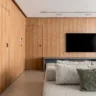 Painel de MDF Carvalho Rovere, da SCA Jardim Europa, integra as portas dos quartos, hall e lavabo deste apartamento reformado pela arquiteta Gabriela Prado | Foto: Rafael Renzo