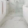 Nos banheiros, os ralos invisíveis são executados nos sistemas linear e square, cada um com suas minúcias que complementam a sobriedade que entregam aos ambientes. Nesse projeto, a arquiteta Isabella Nalon adotou o ralo, também considerado como invisível, no box e do lado de fora | Foto: Julia Herman 