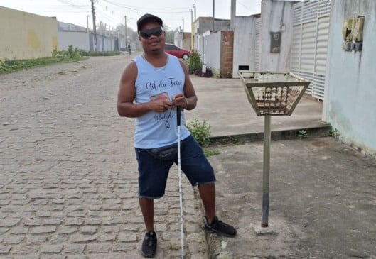 Deficiente visual relata dificuldades para se locomover por rua com buracos