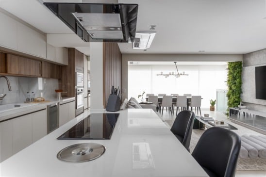 Nos projetos residenciais, a cozinha integrada deixou de ser um dilema, assim como nesse projeto realizado pelas arquitetas Fabiana Villegas e Gabriela Vilarrubia. Por aqui, a cozinha corredor ganhou uma península com múltiplas funções: além de receber o cooktop de indução, tornou-se bancada para refeições rápidas e uma área de interação quando os moradores recebem convidados | Projeto: Vilaville Arquitetura | Foto: JP Imagem