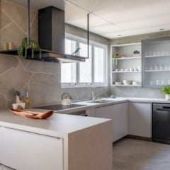 No projeto dessa cozinha, o arquiteto Raphael Wittmann adornou as paredes com o mesmo porcelanato do piso, mas de uma outra maneira: ousou a produzir recortes orgânicos, realizados na obra, para entregar um toque moderno e natural ao ambiente | Projeto Rawi Arquitetura + Design | Foto: Rafael Renzo
