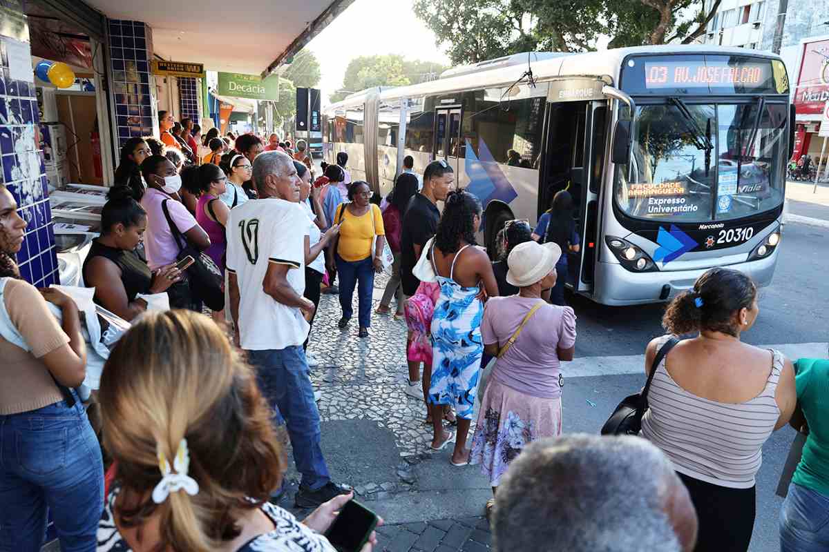Pessoas em ponto de ônibus no comércio de Feira de Santana