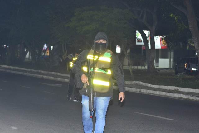 Policial atuando como assaltante durante simulação de ataque a banco