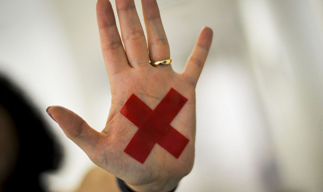 O sinal “X” feito com batom vermelho (ou qualquer outro material) na palma da mão ou em um pedaço de papel, o que for mais fácil, permite que a pessoa treinada reconheça que aquela mulher foi vítima de violência doméstica e, assim, acione a Polícia Militar.