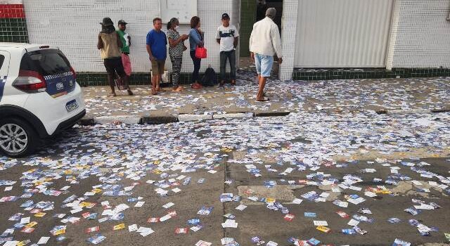eleitores chegam cedo pra votar, ruas sujas com santinhos