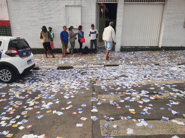 eleitores chegam cedo pra votar, ruas sujas com santinhos