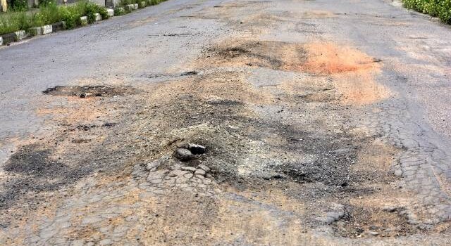 Buracos e mato tomam conta da Avenida Antônio Bernadino de Carvalho, no bairro Pedra do Descanso, na região do Vila Olímpia. (Foto: Ed Santos/Acorda Cidade)