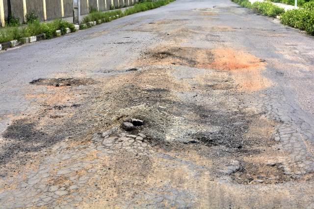 Buracos e mato tomam conta da Avenida Antônio Bernadino de Carvalho, no bairro Pedra do Descanso, na região do Vila Olímpia. (Foto: Ed Santos/Acorda Cidade)