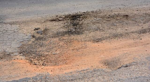 Buracos e mato tomam conta da Avenida Antônio Bernadino de Carvalho, no bairro Pedra do Descanso, na região do Vila Olímpia. (Foto: Ed Santos/Acorda Cidade)
