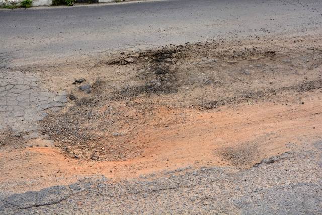 Buracos e mato tomam conta da Avenida Antônio Bernadino de Carvalho, no bairro Pedra do Descanso, na região do Vila Olímpia. (Foto: Ed Santos/Acorda Cidade)