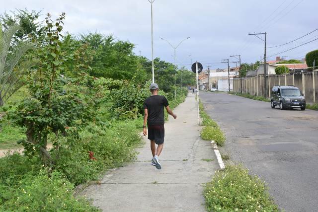 Buracos e mato tomam conta da Avenida Antônio Bernadino de Carvalho, no bairro Pedra do Descanso, na região do Vila Olímpia. (Foto: Ed Santos/Acorda Cidade)