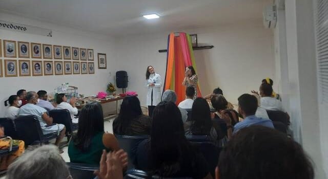A Santa Casa de Misericórdia lançou nesta quarta-feira (25) no auditório da unidade filantrópica uma campanha de doação de livros para o projeto Casa da Leitura. O lançamento realizado às 14h30 contou inicialmente com a participação dos colaboradores da Santa Casa, mas está aberta a toda a sociedade feirense. O objetivo da campanha é montar um acervo para os pacientes das unidades mantidas pela instituição. Também está em andamento a reforma de uma sala onde será instalada a biblioteca. De acordo com a escritora e contadora de histórias Alexandra Patrocínio, que participou do lançamento, a grande importância desse projeto é o seu papel terapêutico junto aos pacientes. “Os pacientes estão passando por problemas tantos emocionais quanto físicos e a imersão no livro, na literatura, tem essa capacidade de transportá-los para esse lugar mágico da leitura e fazer com que eles possam ter momentos de ludicidade, terapêuticos e de cura”, ressaltou. A psicóloga da Santa Casa de Misericórdia, Rafaela Souza, a Casa de Leitura tem como finalidade ser um local criativo e acolhedor para os pacientes das unidades da Santa Casa. “A leitura tem um papel importante, como atividade terapêutica, de auxiliar na ansiedade, na ociosidade. É um espaço acolhedor, tanto para os pacientes, quanto para os acompanhantes, inclusive para a equipe, que tem se engajado e doado de forma muito afetuosa e significativa muitos livros. Realmente foi uma campanha que a Santa Casa abraçou, na pessoa do diretor Rodrigo Matos, e estamos muito felizes, porque sabemos que o ganho maior é para os nossos pacientes, que tanto precisam desse cuidado, dessa assistência”, destacou Rafaela Souza. Ela convocou toda a comunidade para se engajar também neste projeto, doando livros em bom estado de conservação de qualquer gênero da literatura. “Nós esperamos e acreditamos que a comunidade de Feira de Santana vai aderir de forma muito significativa essa campanha. Estamos recebendo livros de vários gêneros literários, como romances, poesias, e também doações de materiais, como artigos de papelaria, lápis de cor, telas, desenhos para colorir, então estamos abertos para receber as doações de Feira de Santana e região. A sala, o local onde vamos construir a biblioteca, já está em reforma e a nossa expectativa é que dentro de 30 dias possamos inaugurar este espaço”, afirmou. Para a psicóloga, o ambiente hospitalar é visto na maior parte do tempo como um local frio de dor e sofrimento. No entanto, a Casa da Leitura busca transformar esse olhar por parte dos pacientes. “A gente vincula, muitas vezes, uma unidade hospitalar a um lugar de perdas e muito sofrimento, e aqui estamos querendo mudar um pouco esse horizonte e mostrar que apesar de todos os tratamentos, todo processo de hospitalização, dentro do hospital a gente pode sim ter um ambiente acolhedor, trabalhar de forma humanizada para dar a esses pacientes uma melhor qualidade de vida, melhor estado no sentido da saúde mental e emocional. Estamos trabalhando para isso, e eu tenho certeza que nossa biblioteca vai nos dar um resultado muito significativo.”