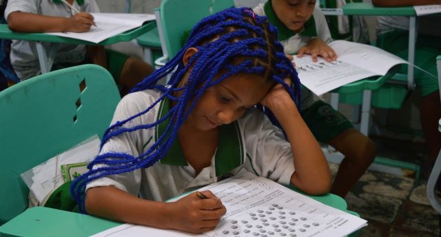 criança lendo escola pública