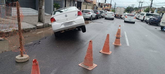 Carro fica preso em buraco